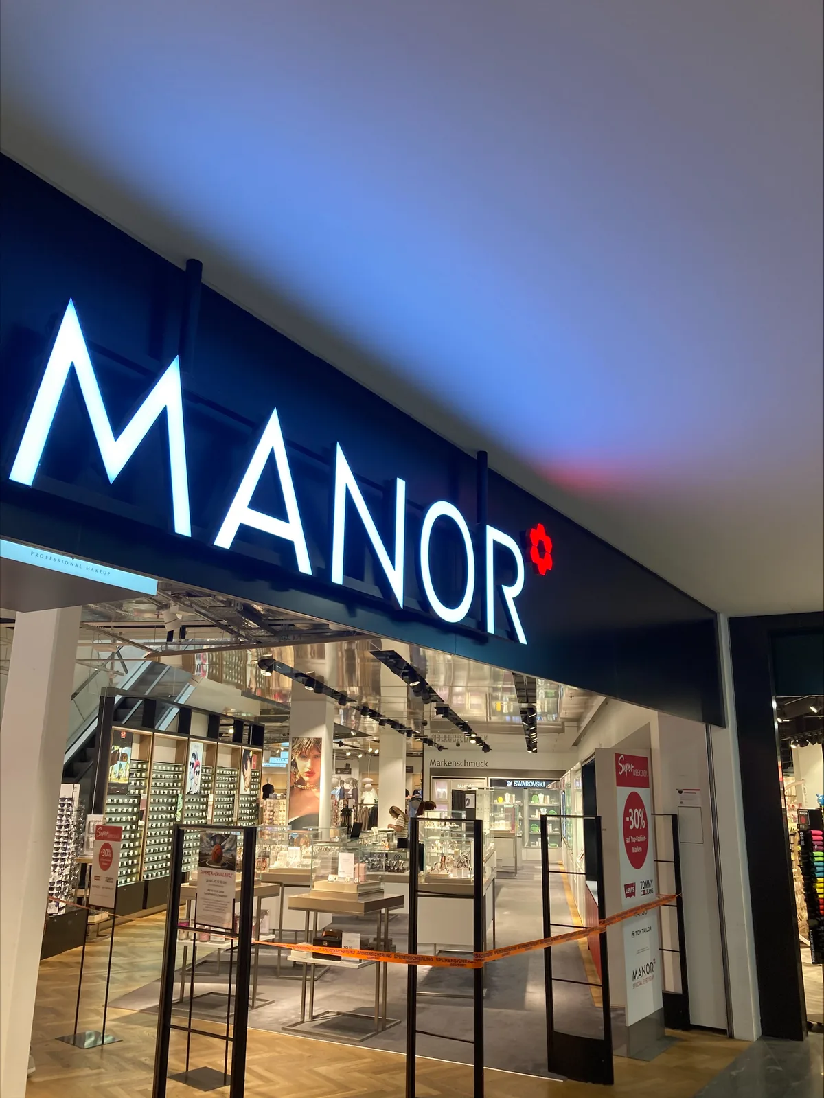 Man sieht ein oranges Absperrband vor Schmuckvitrinen.